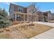 Charming two-story home featuring a stone and tan siding exterior with a three car garage and well-maintained lawn at 6472 N Dunkirk Ct, Aurora, CO 80019