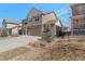 Charming two-story home featuring a stone and tan siding exterior with a three car garage and well-maintained lawn at 6472 N Dunkirk Ct, Aurora, CO 80019