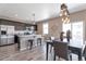 Modern kitchen with stainless steel appliances, center island with barstools, and an open dining area filled with light at 6472 N Dunkirk Ct, Aurora, CO 80019