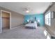 Bright main bedroom features a ceiling fan and tranquil blue accent wall with two sunny windows at 6472 N Dunkirk Ct, Aurora, CO 80019