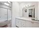 Bright bathroom featuring a vanity with a granite top, large mirror and a shower and bathtub combination with white tiled walls at 1254 S Yosemite Way # 99, Denver, CO 80247