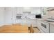 Well-lit kitchen featuring white cabinets, modern appliances, and a cozy breakfast table at 1254 S Yosemite Way # 99, Denver, CO 80247