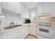 Close-up view of a kitchen with white cabinetry, countertops, and modern appliances at 1254 S Yosemite Way # 99, Denver, CO 80247