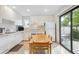 Bright kitchen with white cabinets, dining table, and sliding glass door at 1254 S Yosemite Way # 99, Denver, CO 80247