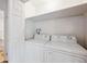 A bright laundry room featuring a white washer and dryer and a white bi-fold door at 1254 S Yosemite Way # 99, Denver, CO 80247