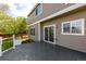 A back deck area is viewed featuring gray wood, railing, and sliding glass door access to the home's interior at 1041 Riddlewood Rd, Highlands Ranch, CO 80129