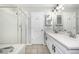 Well-lit bathroom with double vanity, frameless shower, and modern fixtures at 1041 Riddlewood Rd, Highlands Ranch, CO 80129