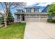 Charming two-story home features a large driveway and an attached three car garage at 1041 Riddlewood Rd, Highlands Ranch, CO 80129