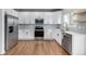 Contemporary kitchen showcasing stainless steel appliances, white cabinetry, and hardwood flooring at 1041 Riddlewood Rd, Highlands Ranch, CO 80129