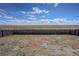 Expansive backyard view with a brown wood fence bordering open fields under a sunny sky at 188 S Waterloo St, Aurora, CO 80018