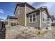 Side exterior showing neutral siding, white trim, and partial stone foundation on an unfinished lot at 188 S Waterloo St, Aurora, CO 80018