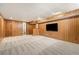 Finished basement with wood paneling, carpet, and a small bar area perfect for entertaining at 6300 W Mansfield Ave # 61, Denver, CO 80235