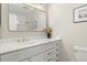 Bathroom showcasing white vanity, quartz countertop, gold fixtures, and framed mirror at 6300 W Mansfield Ave # 61, Denver, CO 80235