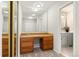 Dressing area with wood vanity, large mirror and entry to the ensuite bathroom at 6300 W Mansfield Ave # 61, Denver, CO 80235