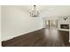 Open living room showing dark wood floors and fireplace with an elegant chandelier at 6300 W Mansfield Ave # 61, Denver, CO 80235
