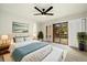 Light filled main bedroom with a ceiling fan and sliding glass door access to the deck at 6300 W Mansfield Ave # 61, Denver, CO 80235