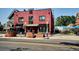 Commercial building featuring a red brick exterior, large windows, awnings, outdoor seating, and street-side signage at 2731 W 32Nd Ave, Denver, CO 80211