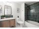 Bathroom featuring a wood vanity, gold fixtures, green tiling and a shower-tub combination at 11525 Eaton Ct, Westminster, CO 80020