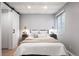 Cozy bedroom with white bedding, two bedside tables, and a barn door at 11525 Eaton Ct, Westminster, CO 80020