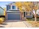 Inviting two-story home featuring a blue exterior, brick accents, well-kept lawn, and a spacious two-car garage at 11525 Eaton Ct, Westminster, CO 80020