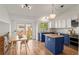 Modern kitchen with blue and white cabinets, stainless steel appliances, and a dining area with natural light at 11525 Eaton Ct, Westminster, CO 80020