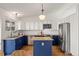 Well-lit kitchen with blue and white cabinets, stainless steel appliances, and modern fixtures at 11525 Eaton Ct, Westminster, CO 80020