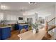 Open-concept kitchen featuring blue and white cabinets, stainless steel appliances, and a view into the living room at 11525 Eaton Ct, Westminster, CO 80020