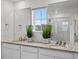 Bathroom featuring dual sinks, granite counters, and a large vanity mirror at 9446 Quintero St, Commerce City, CO 80022