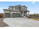Exterior view of a two-story home with three-car garage and cozy front porch with nice landscaping at 9446 Quintero St, Commerce City, CO 80022