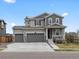 Two-story home featuring a three-car garage, charming front porch, and well-maintained landscaping at 9446 Quintero St, Commerce City, CO 80022