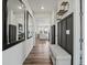 Inviting hallway with wood floors, decorative mirrors, and accent wall with bench at 9446 Quintero St, Commerce City, CO 80022