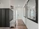 Hallway featuring wood floors, a bench, mirrors, and a decorative accent wall at 9446 Quintero St, Commerce City, CO 80022