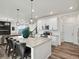 Modern kitchen with island seating, stylish pendants, and seamless connectivity to the living area at 9446 Quintero St, Commerce City, CO 80022