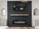 Close-up of a modern fireplace with sleek black paneling and decorative sideboards at 9446 Quintero St, Commerce City, CO 80022