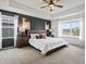 Main bedroom featuring a decorative accent wall, tray ceiling, and bedside tables at 9446 Quintero St, Commerce City, CO 80022