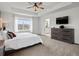 Spacious main bedroom with tray ceiling, ceiling fan, and large windows at 9446 Quintero St, Commerce City, CO 80022
