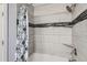 Bathroom featuring tiled shower and tub with stylish, patterned shower curtain at 1818 S Quebec Way # 11-8, Denver, CO 80231