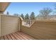 View from the deck with wood railings and wood floor and serene views of trees and blue sky at 1818 S Quebec Way # 11-8, Denver, CO 80231