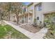 Exterior view of a row of townhouses with a walkway, manicured landscaping, and mature trees at 1818 S Quebec Way # 11-8, Denver, CO 80231