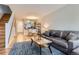 Inviting living room featuring a comfortable leather sofa, stylish rug, and an open layout to the dining area at 1818 S Quebec Way # 11-8, Denver, CO 80231