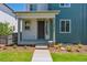 Charming home's front porch with stone steps, manicured lawn, and craftsman pillars at 14123 Deertrack Ln, Parker, CO 80134
