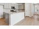 Bright kitchen features gray cabinets, stainless steel appliances, island and wood flooring at 14123 Deertrack Ln, Parker, CO 80134