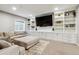 Cozy living room features custom built-ins, a large TV, comfortable seating and natural light at 16201 Lanceleaf Pl, Parker, CO 80134