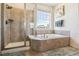 Serene main bathroom featuring a soaking tub, a separate shower, and neutral tile, creating a spa-like experience at 16201 Lanceleaf Pl, Parker, CO 80134