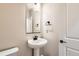 Powder room featuring modern fixtures, a pedestal sink, and neutral decor at 4104 Grand Lake St, Brighton, CO 80601