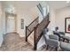 Bright foyer with hardwood floors, staircase with dark wood railing, and contemporary light fixtures, creating a welcoming entrance at 5535 W 96Th Pl, Westminster, CO 80020