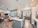 Open concept kitchen features stainless appliances, center island with cooktop, and seamless flow into the living and dining areas at 5535 W 96Th Pl, Westminster, CO 80020