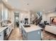 Bright kitchen features white cabinets, a gray island with a cooktop, and seamless flow into the open concept living area at 5535 W 96Th Pl, Westminster, CO 80020