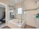 Bright bathroom featuring a soaking tub, separate shower, and decorative details at 5535 W 96Th Pl, Westminster, CO 80020