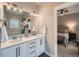 This main bathroom offers double sinks and mirrors, and a view to the bedroom through an open doorway at 5535 W 96Th Pl, Westminster, CO 80020